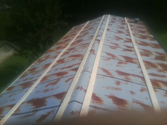 Rusted metal roof panels with new wood purlins before replacement — Storm Damage Roof Repair in Monticello by Roofing Brothers